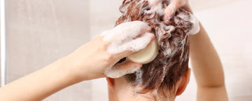 Woman washing her hair with cold water