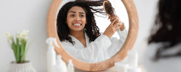 Woman trying to comb her matted hair