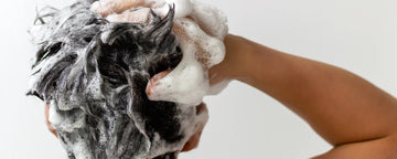 Man washes his hair with shampoo