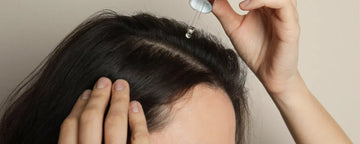 Woman uses hair oil to moizsture her scalp